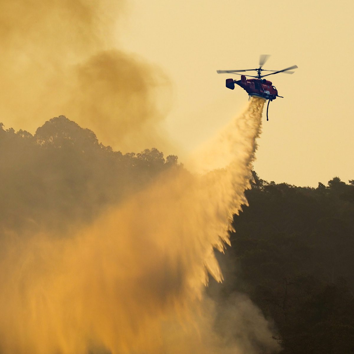Image of a fire fighter helicopter dropping water on wildfires, representing crisis emergency planning