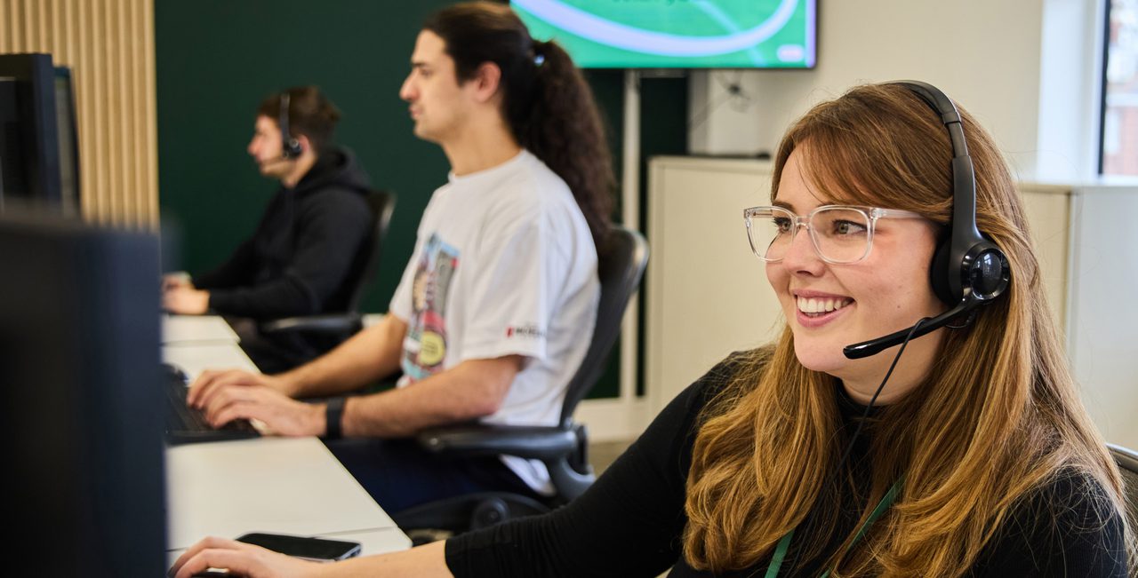 Assistance coordinator speaking calmly on the phone, providing support to a business traveller abroad